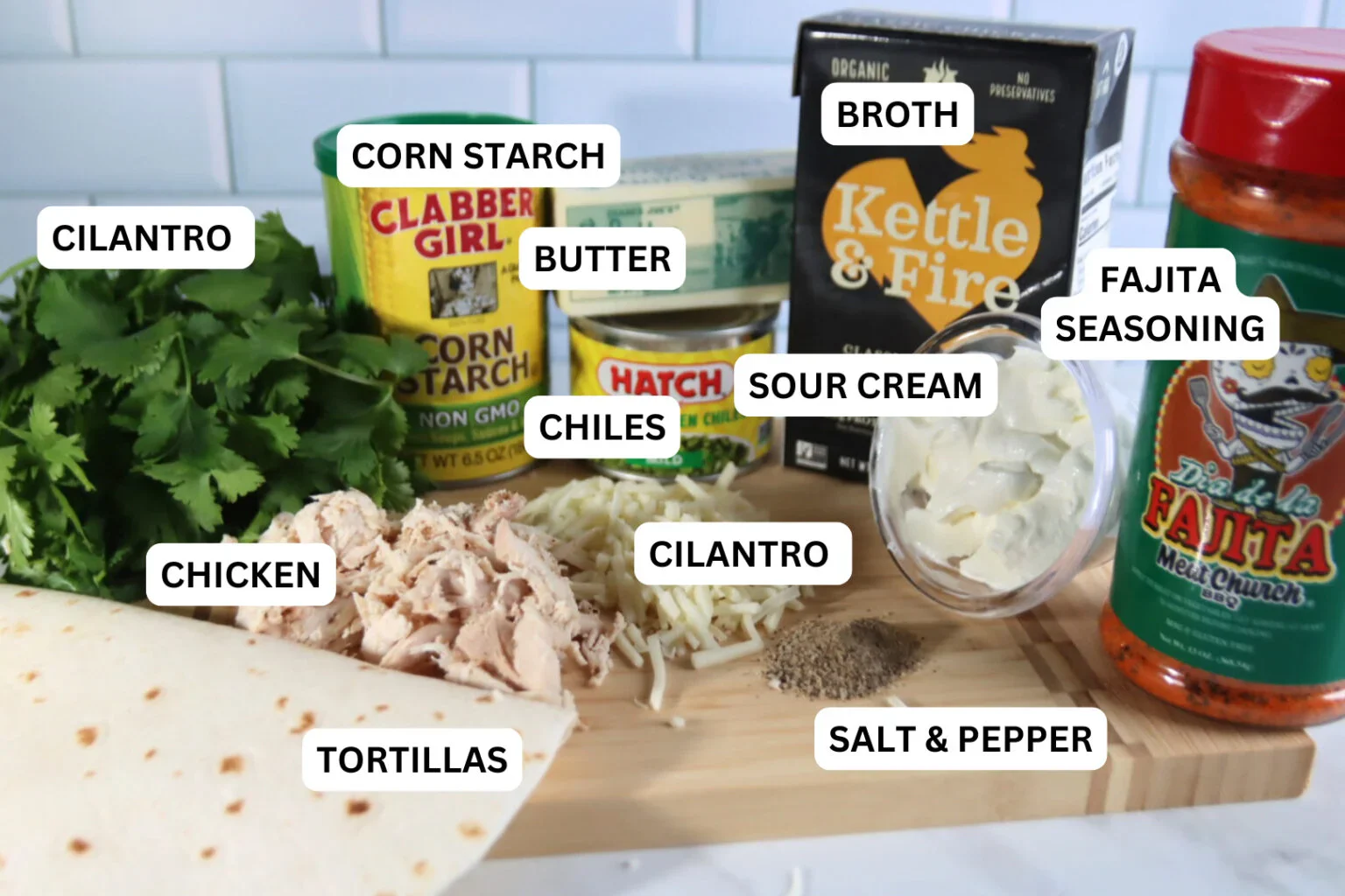 Ingredients for white chicken enchiladas, including tortillas, chicken, Monterey Jack cheese, sour cream, green chiles, broth, butter, cornstarch, cilantro, and fajita seasoning.